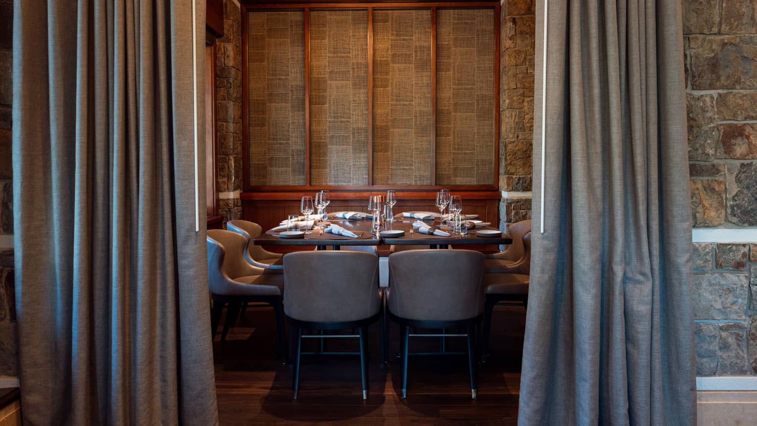 A dining room with stone walls and a modern, circular chandelier