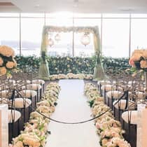 Wedding ceremony set-up, bouquets of flowers along aisle leading to altar with lanterns by window