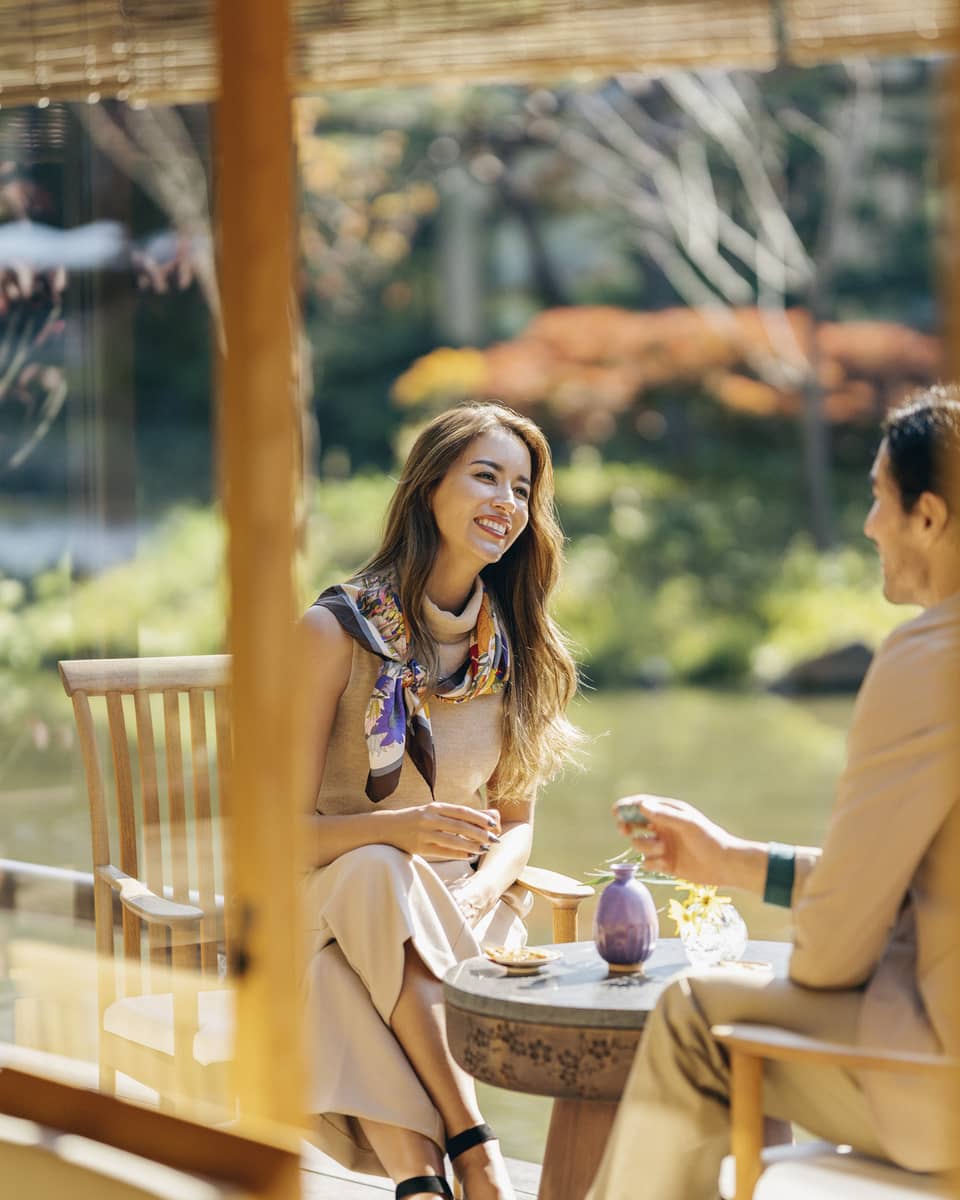 Smiling couple enjoys romantic dinner at Fuju's Shakusui-en pond garden
