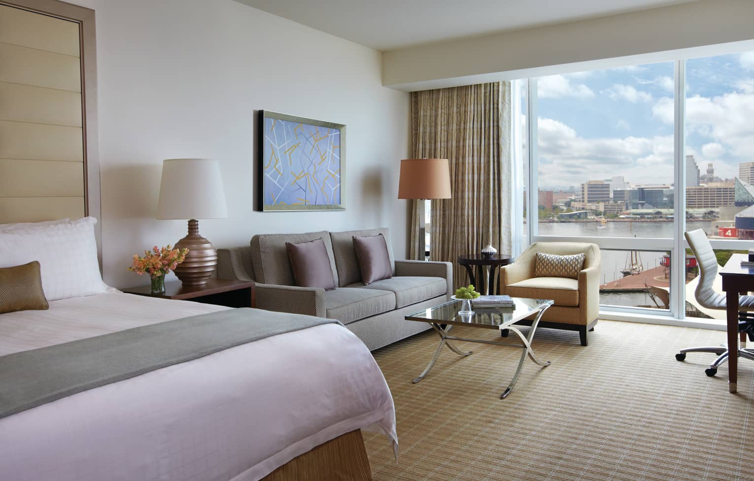 Harbour View hotel room end of bed with sash, loveseat chair by glass wall, balcony