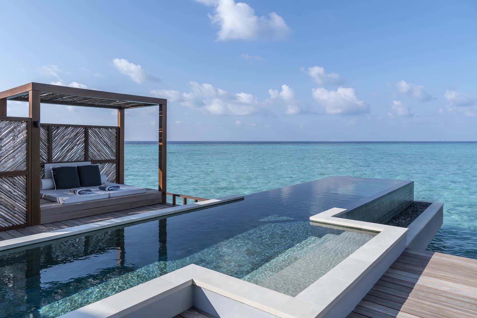 An oceanside infinity pool with a covered cabana 