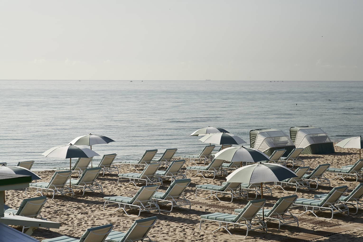 Lounge chairs and umbrellas on a sandy beach.