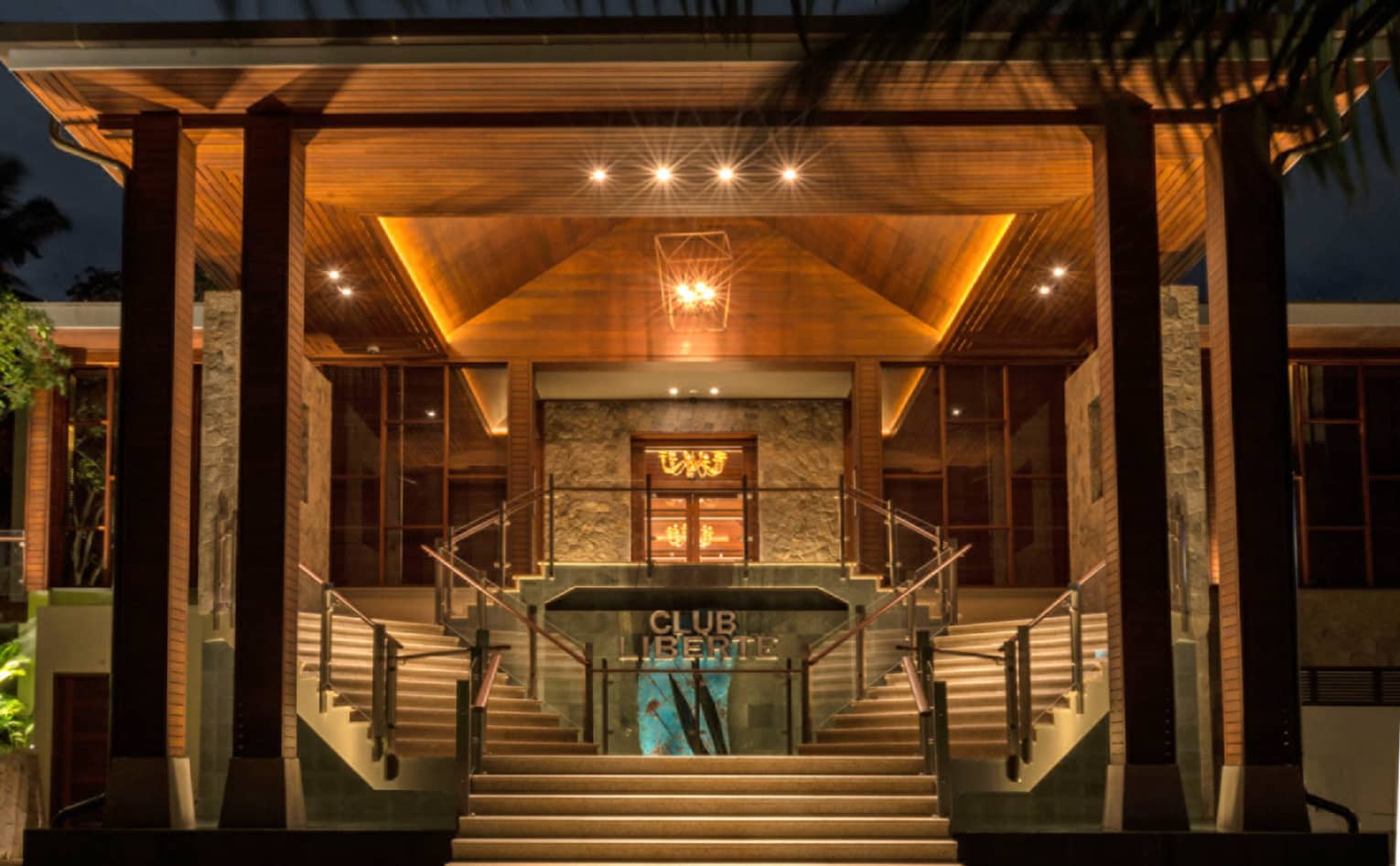 Entrance to Club Liberte, illuminated at night, two stair cases on each side of entry way