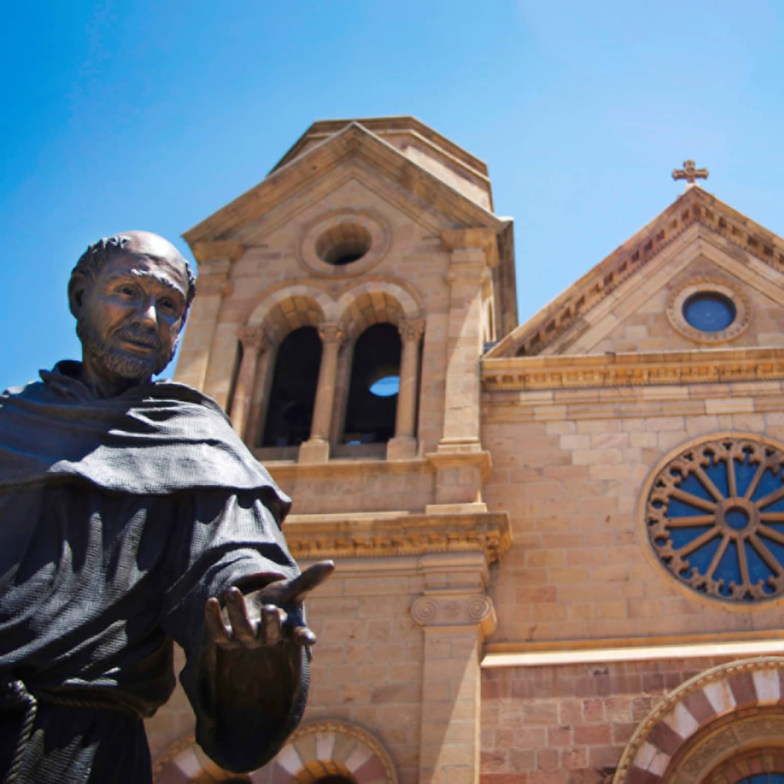 Statue of monk in front of stone New Mexico cathedral church