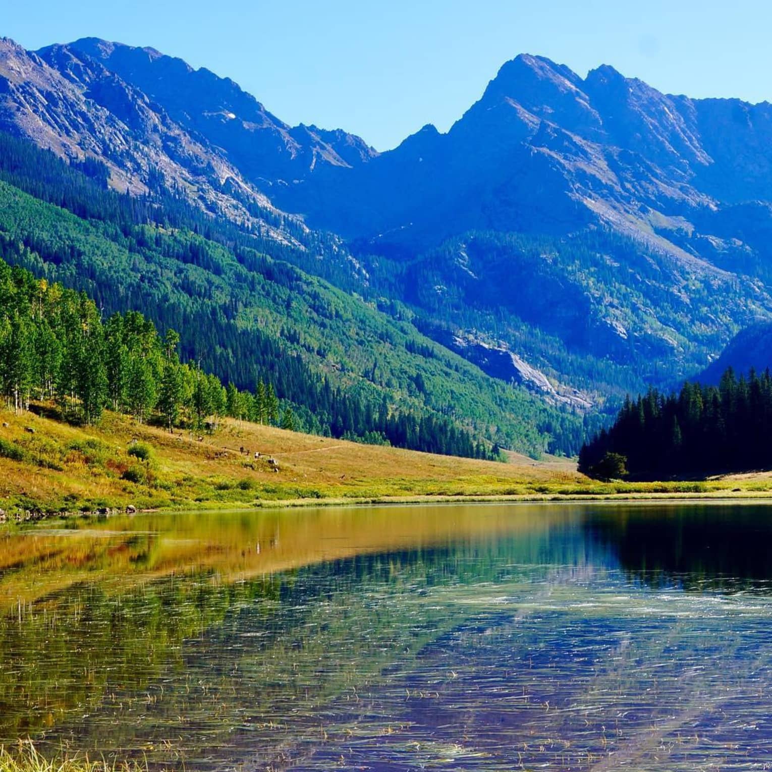 Blue light over mountains, lake with canoes