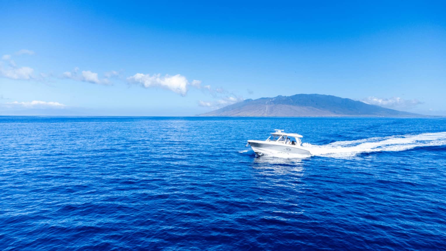 A boat on the water with island in the background