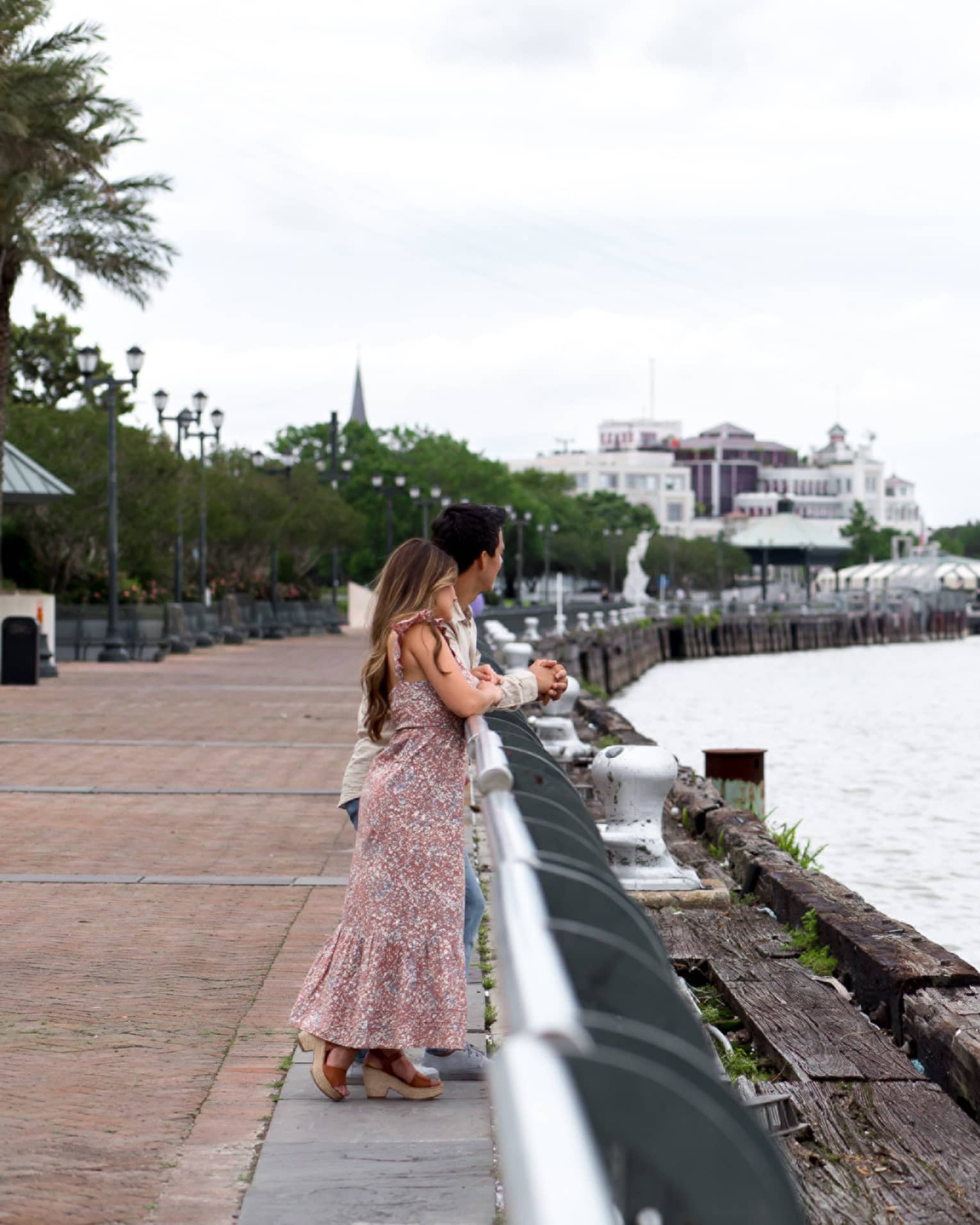 A woman and man looking out a river.