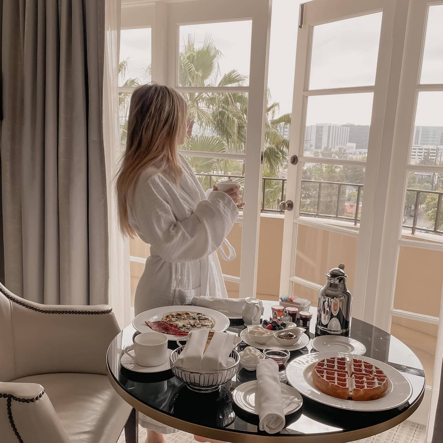 Woman eating breakfast looking out at city view