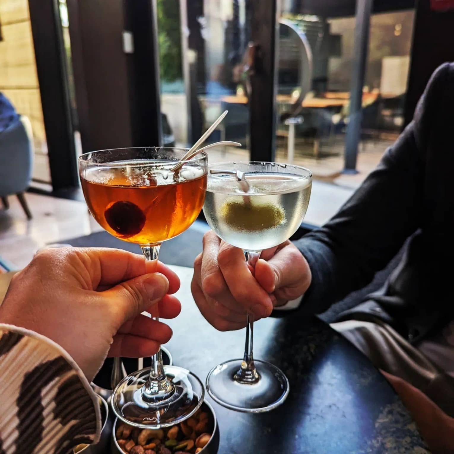 ,Two people enjoy chilled cocktails at a restaurant 