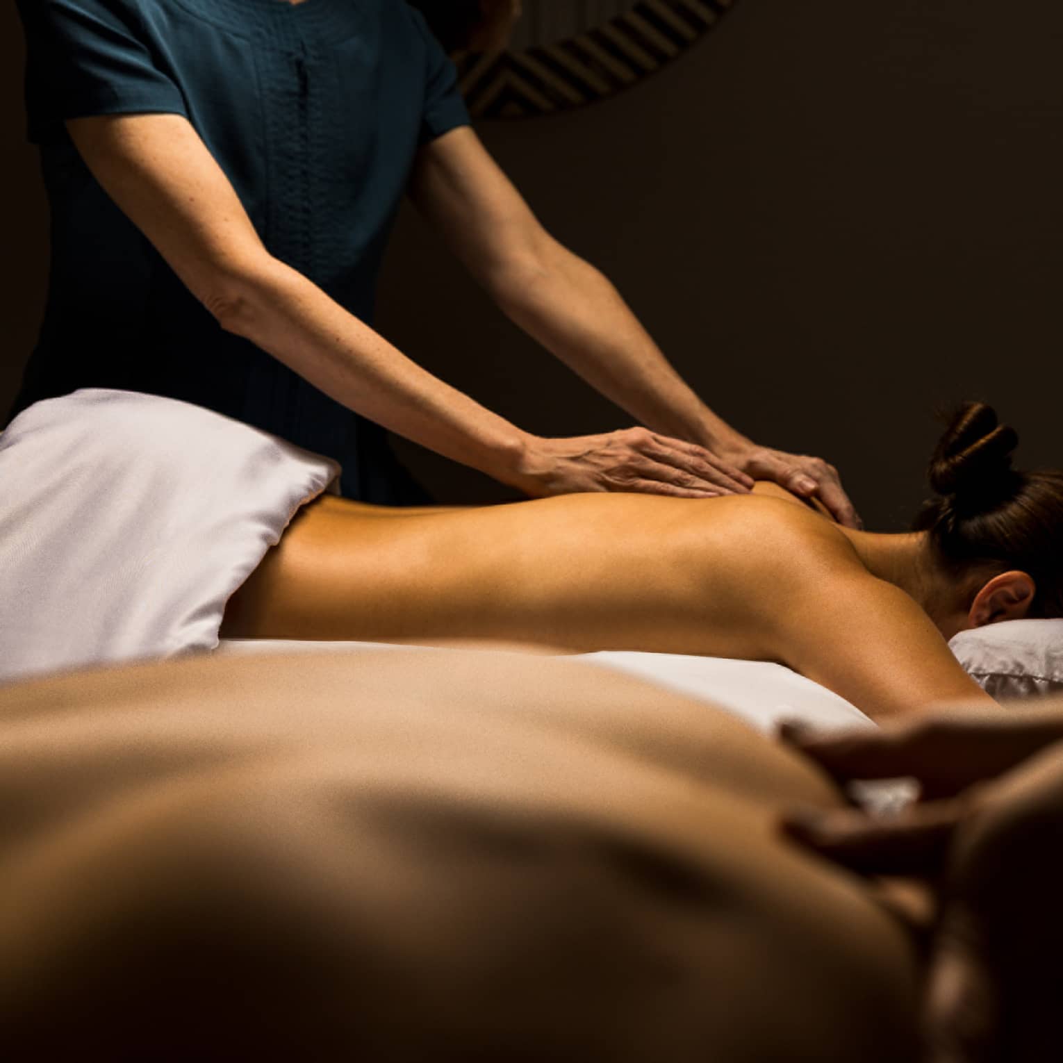 Two guests lay side by side for massage treatments