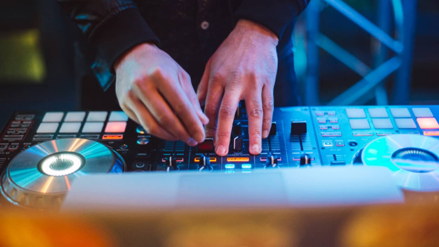 A DJ mixes music on a DJ mixer