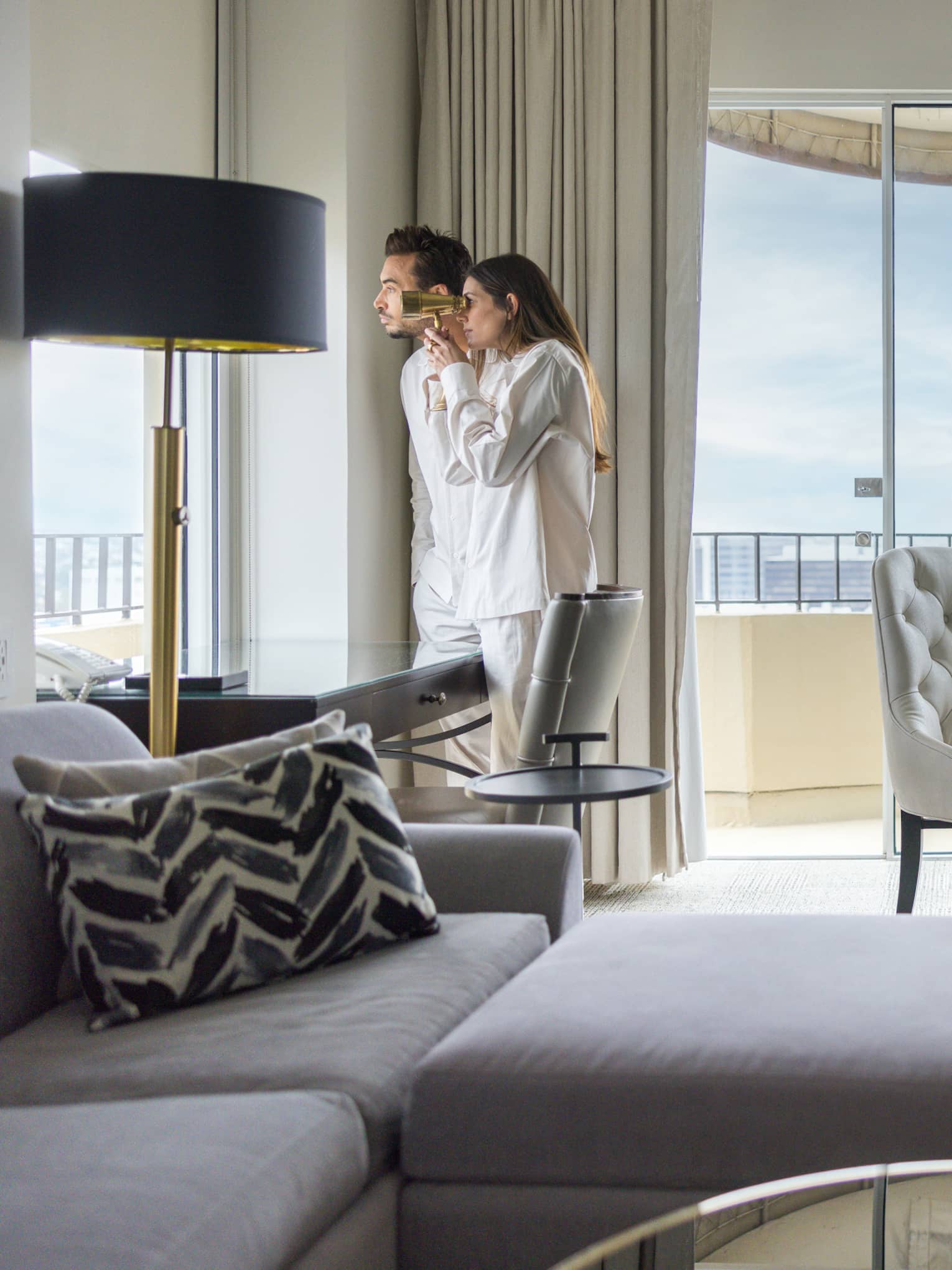 Two guests looking out of the window of their guest room
