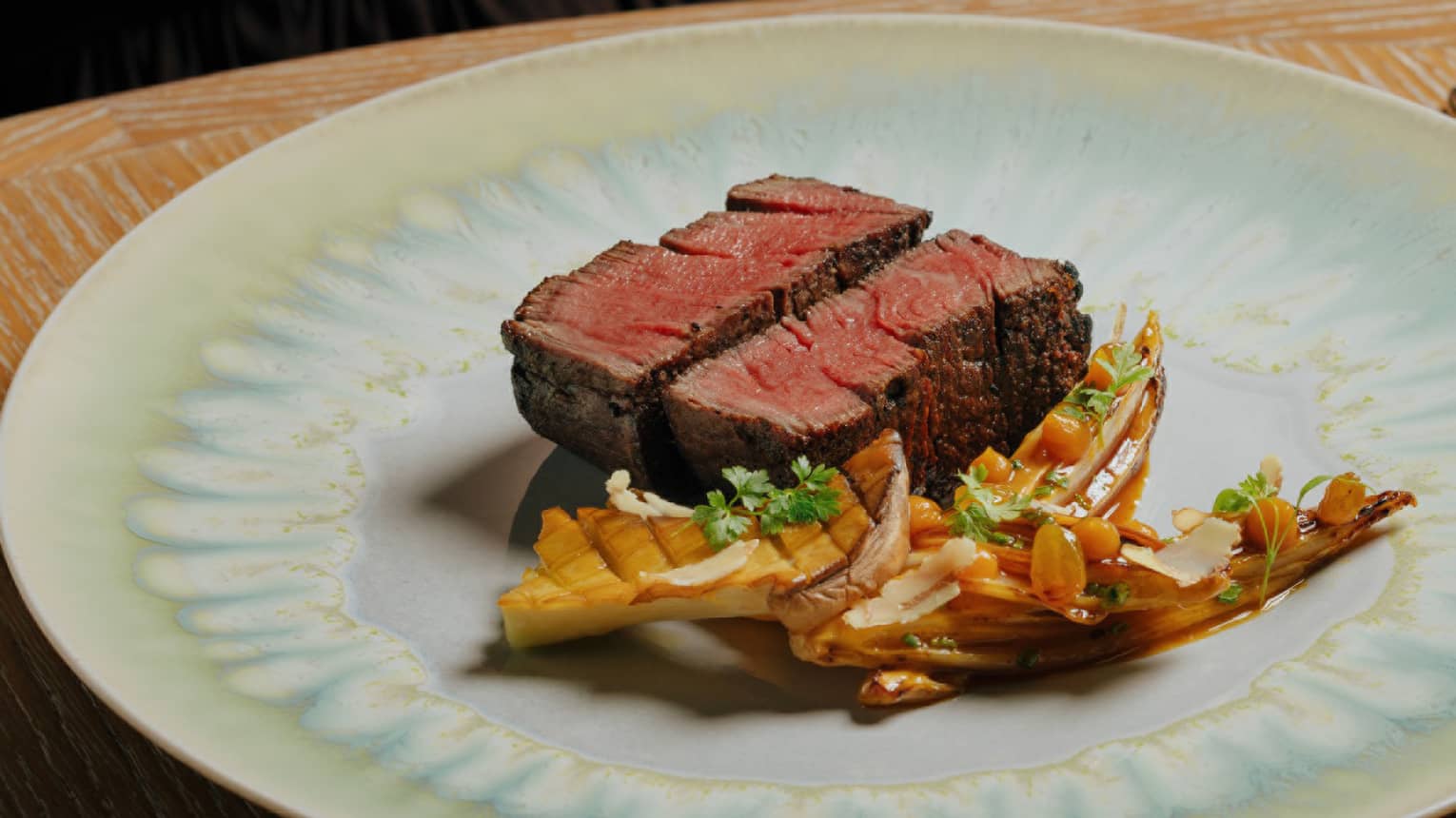 Wagyu Beef Filet served with braised endive, orange, thyme, golden raisins and walnuts