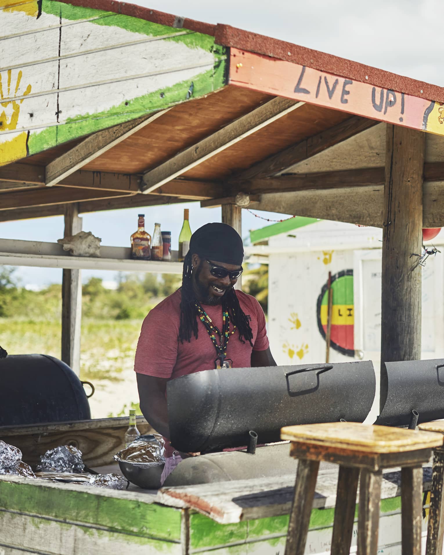 Smiling man grilling at colourful outdoor barbecue stand