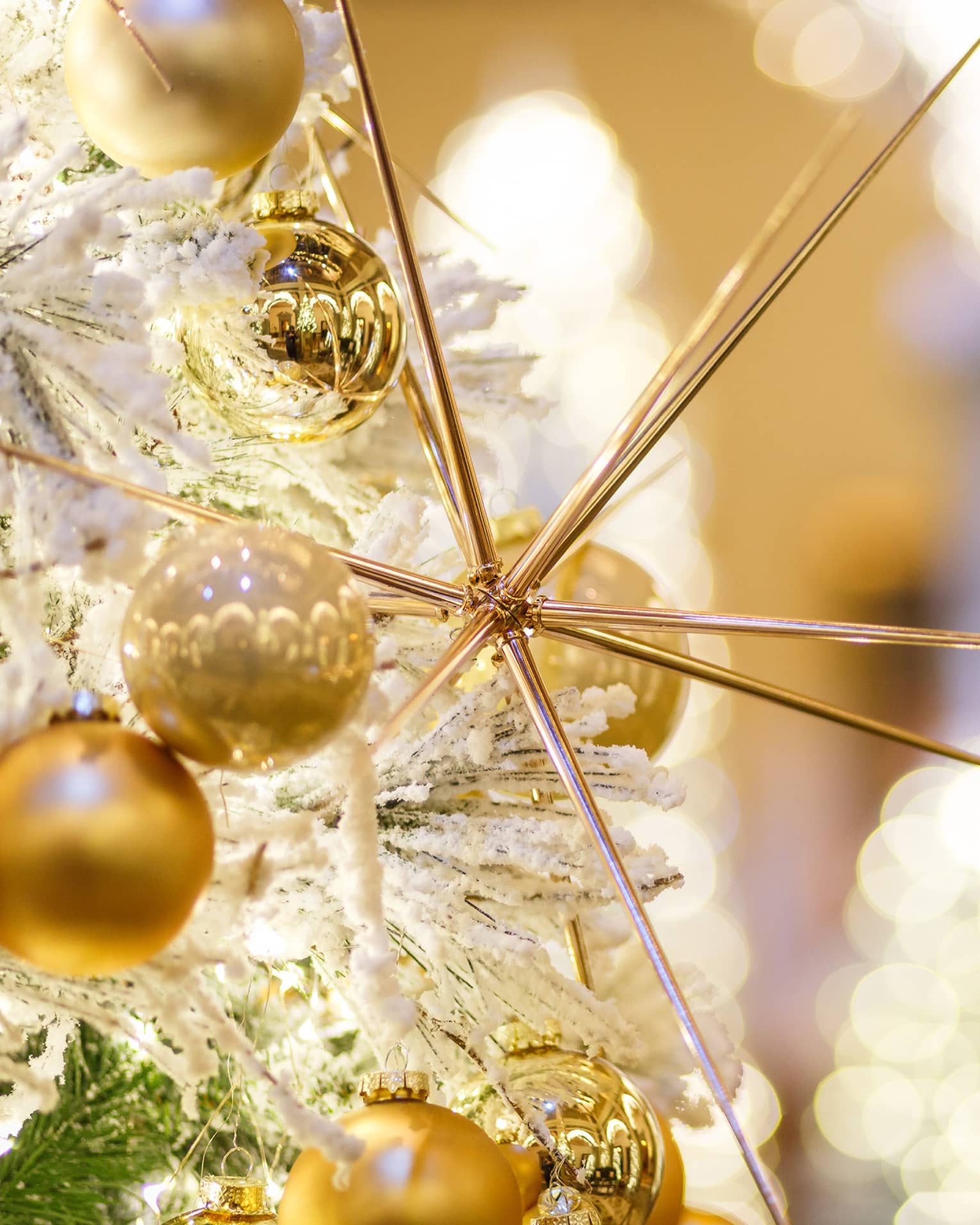 Close up of gold Christmas ornaments in the shape of a sphere and needles.