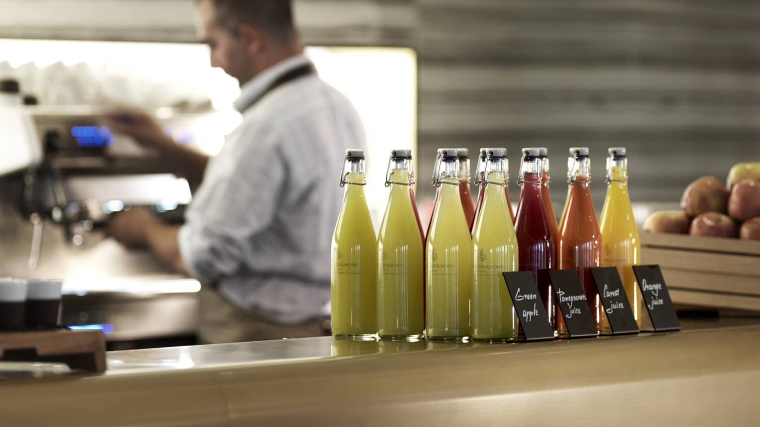 Several pressed juices sealed in glass jars on a countertop. 