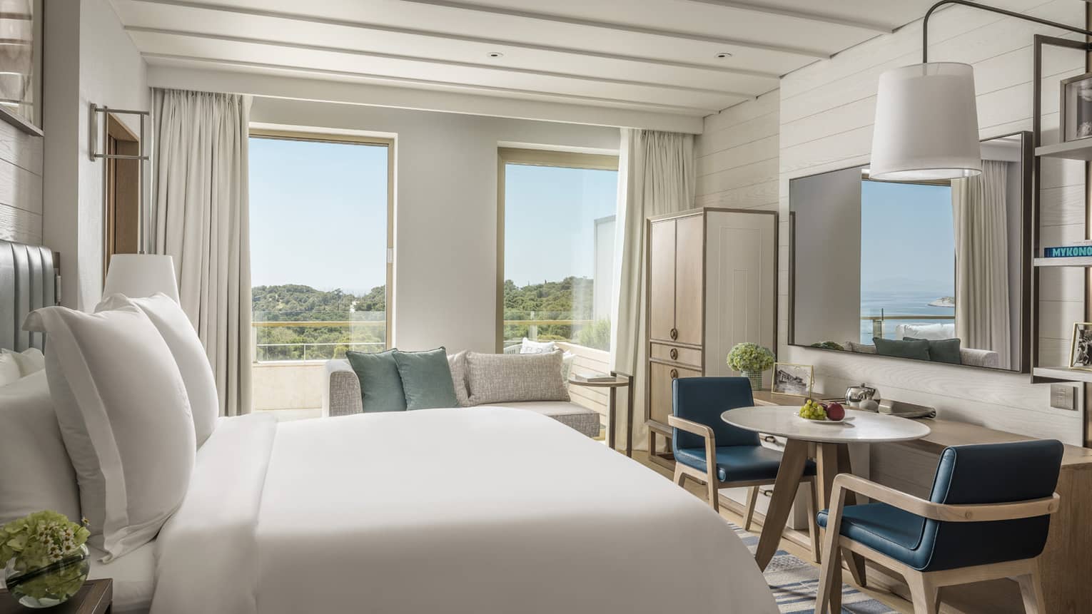 Stylish Arion Pine View Room with white bedding, blue accent furniture and views of trees