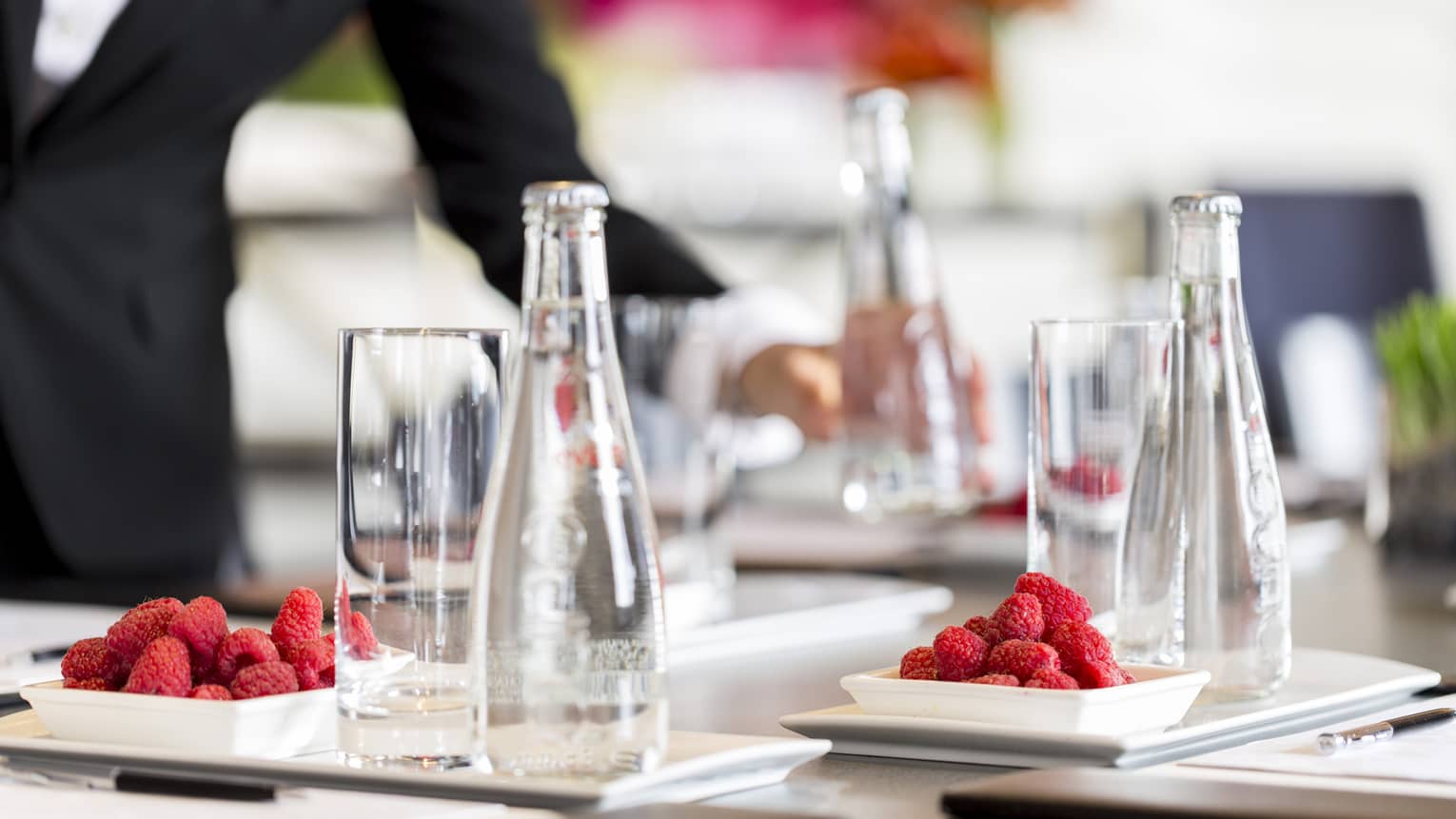 Close-up of tall glass, water bottle on conference meeting table