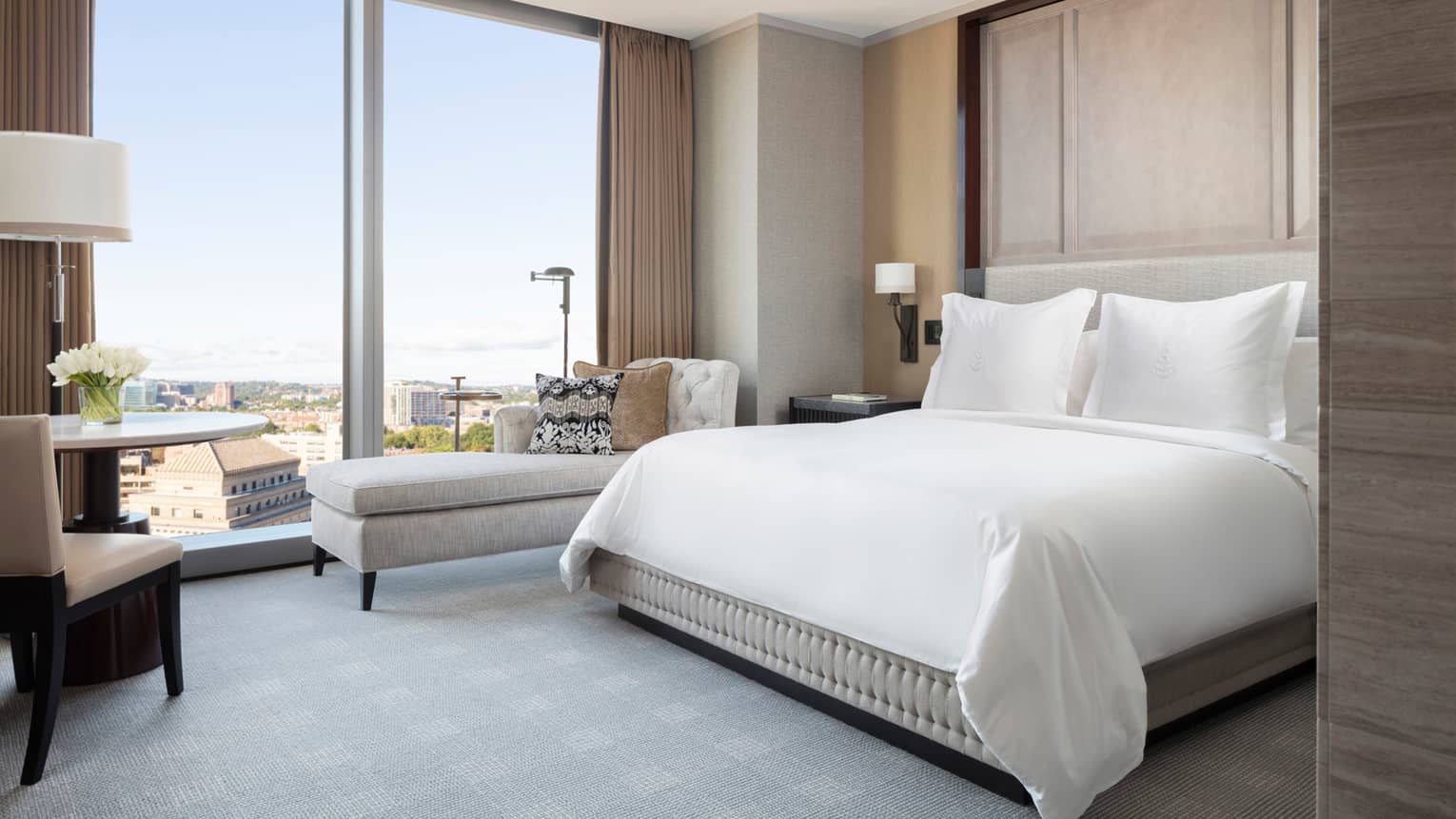 guests room with queen bed, lounge couch, desk area and floor to ceiling window at four seasons hotel boston one dalton 