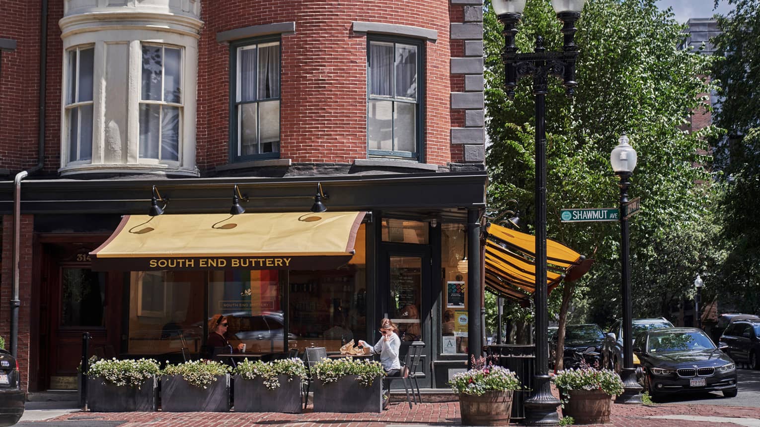 People sit at a table in an outdoor terrace of a restaurant