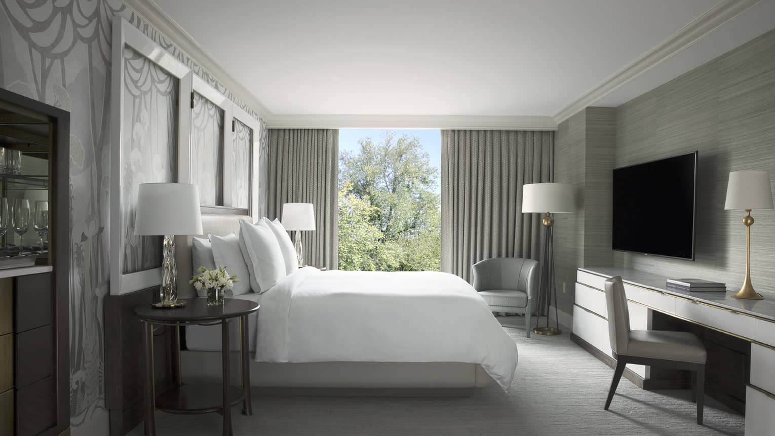 Garden Suite hotel room bed with white linens across from desk, tv 