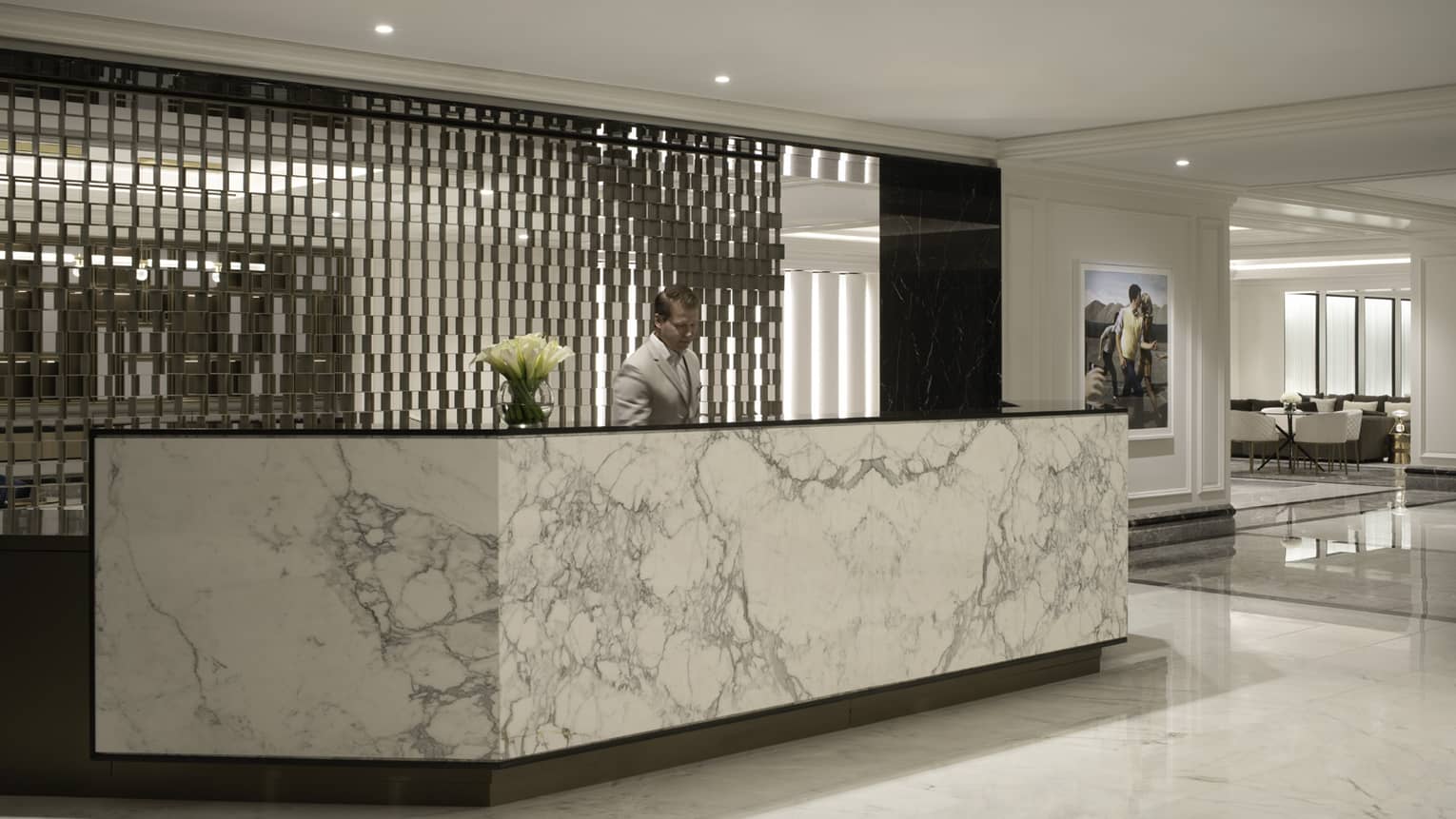 Modern lobby with marble check-in counter and man behind it