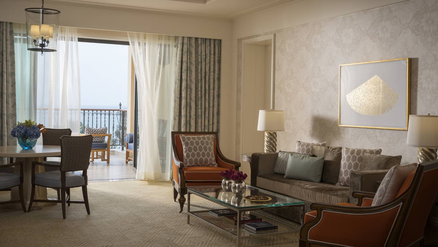 Jumeirah Sea-View Suite with large living space, orange and gold accents, white curtains