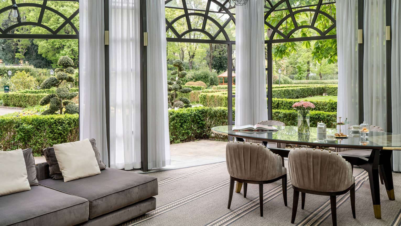 Living and dining area that opens to a lush garden