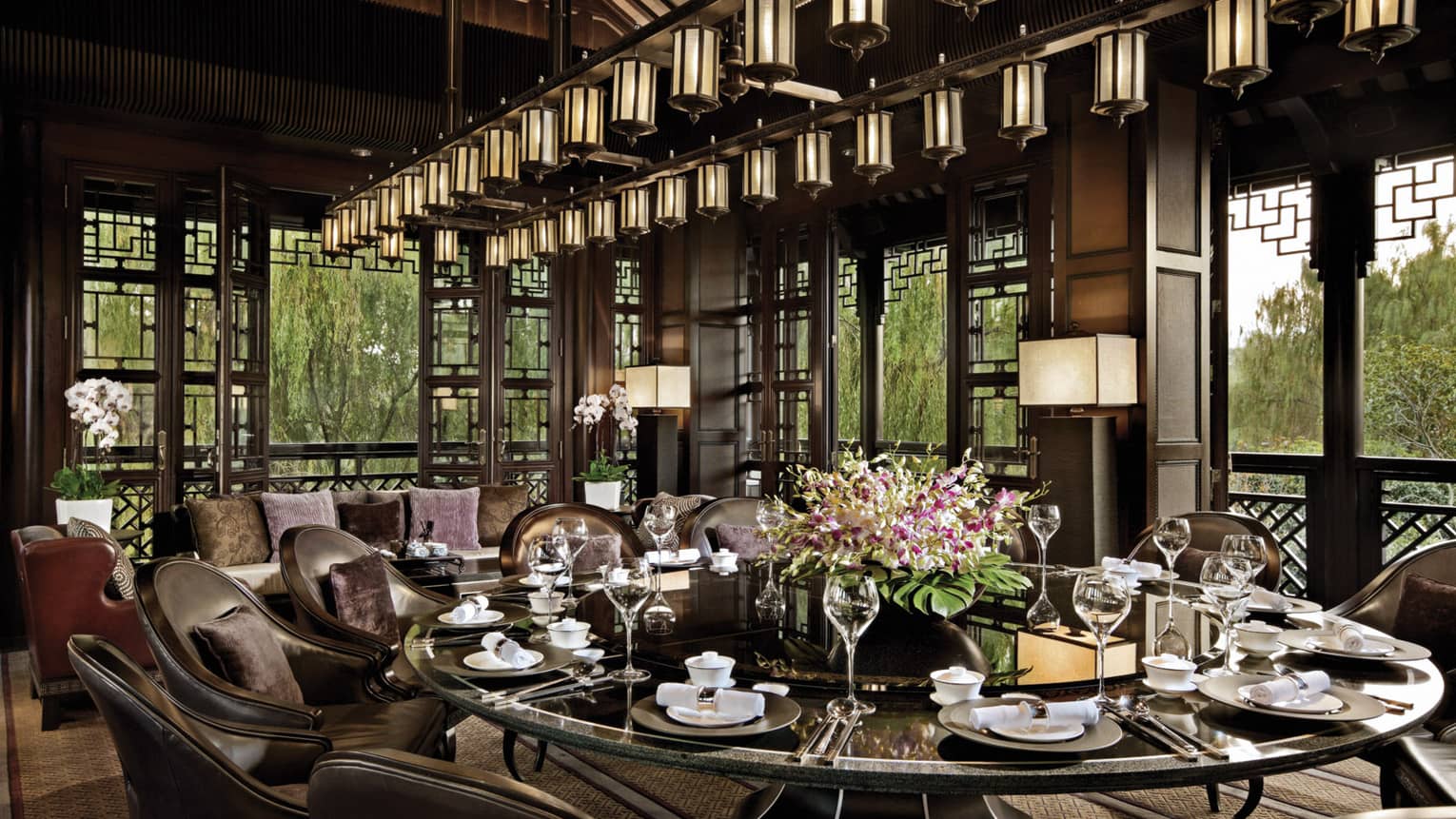 Large round, black, shiny dining table under lantern chandelier at Jin Sha