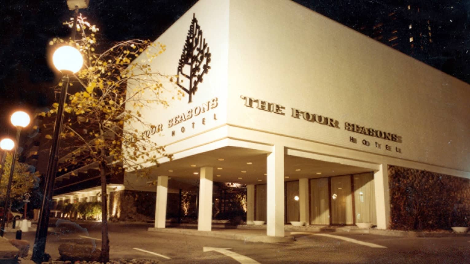 Historic 1960s photo of corner of white Four Seasons Hotel building at night