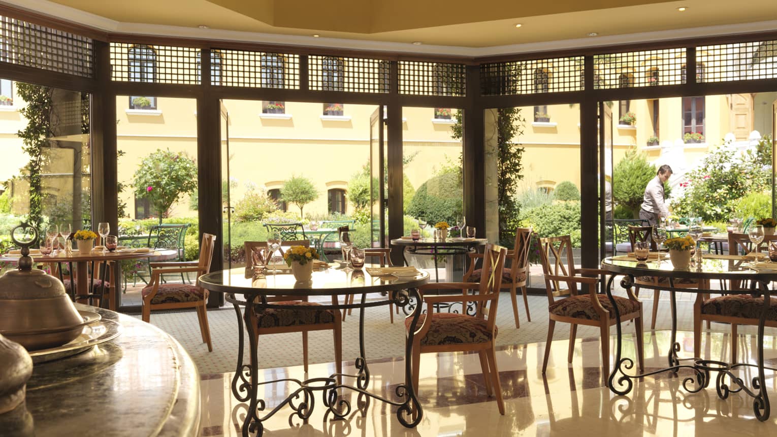 Seasons open air dining room with glass walls opening to sunny terrace