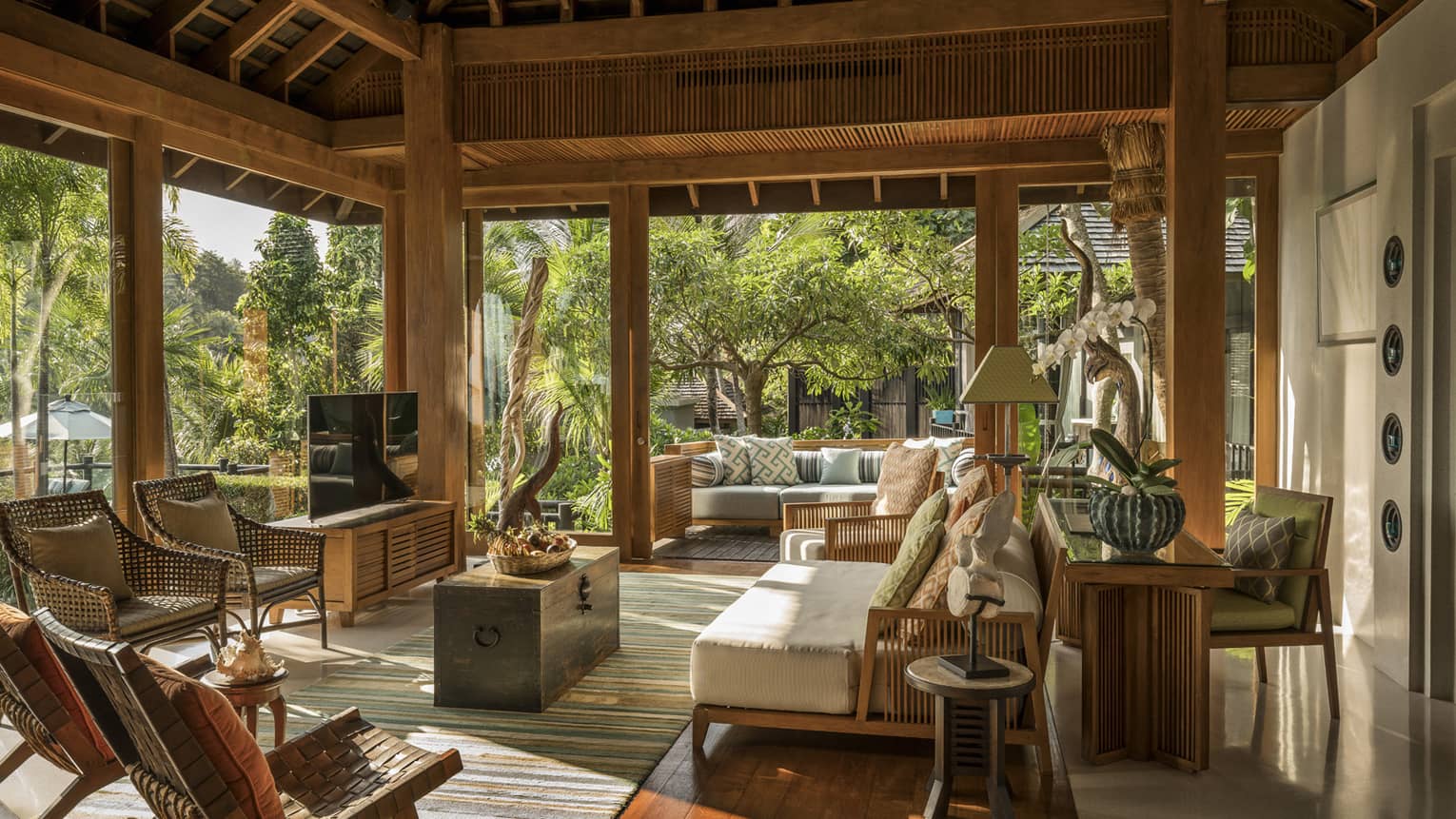 Wicker patio furniture, plush sofa under roof in open-air living room