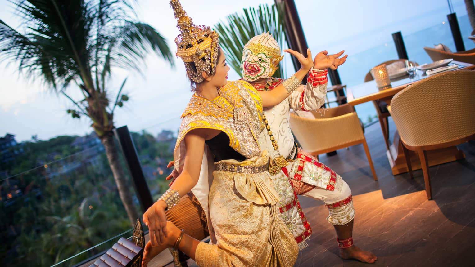 Two dancers in colourful traditional outfits perform outdoors, embodying cultural heritage and festive spirit.