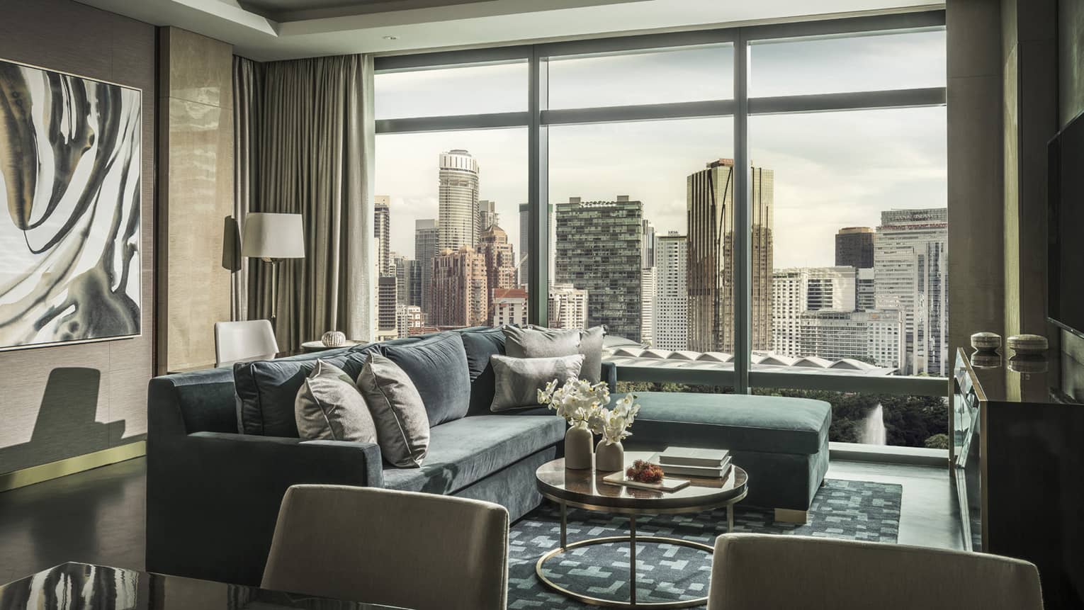 Stylish living room with L-shaped sofa, round coffee table and floor-to-ceiling windows