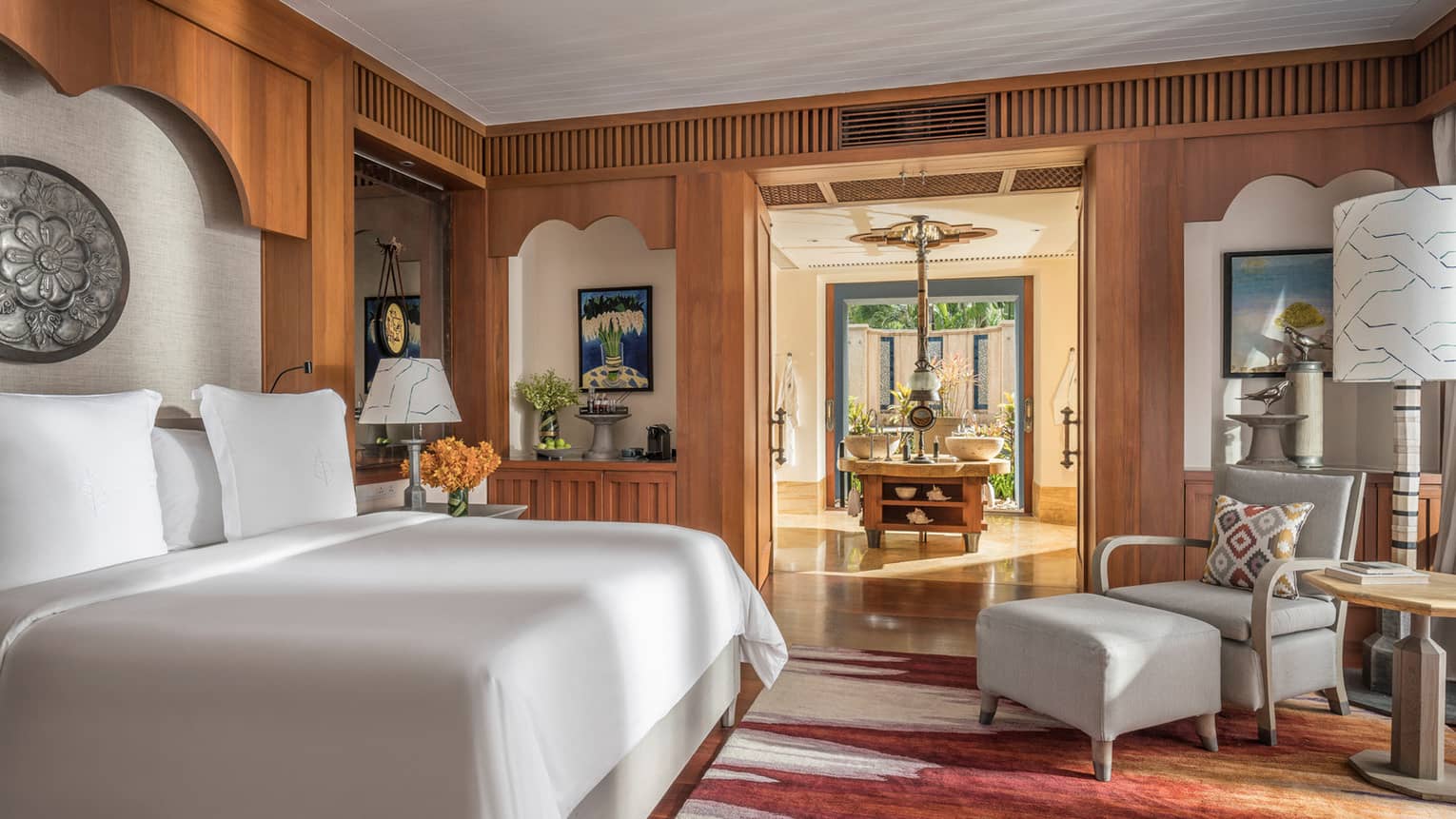Lower Pavilion Room with white bed and gray club chair
