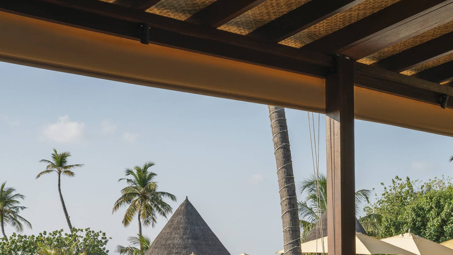 Open-air restaurant Caf� Huraa with rattan chairs and blonde wood tables, overlooking the pool