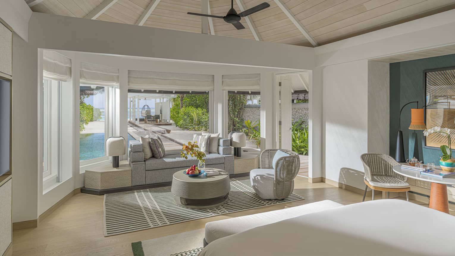 Interior bedroom with sitting area and vaulted ceiling in a luxury villa at tropical resort