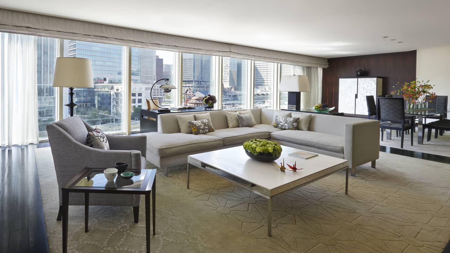 Chairman's Suite modern L-shaped grey sofa, armchair coffee table, wall of windows