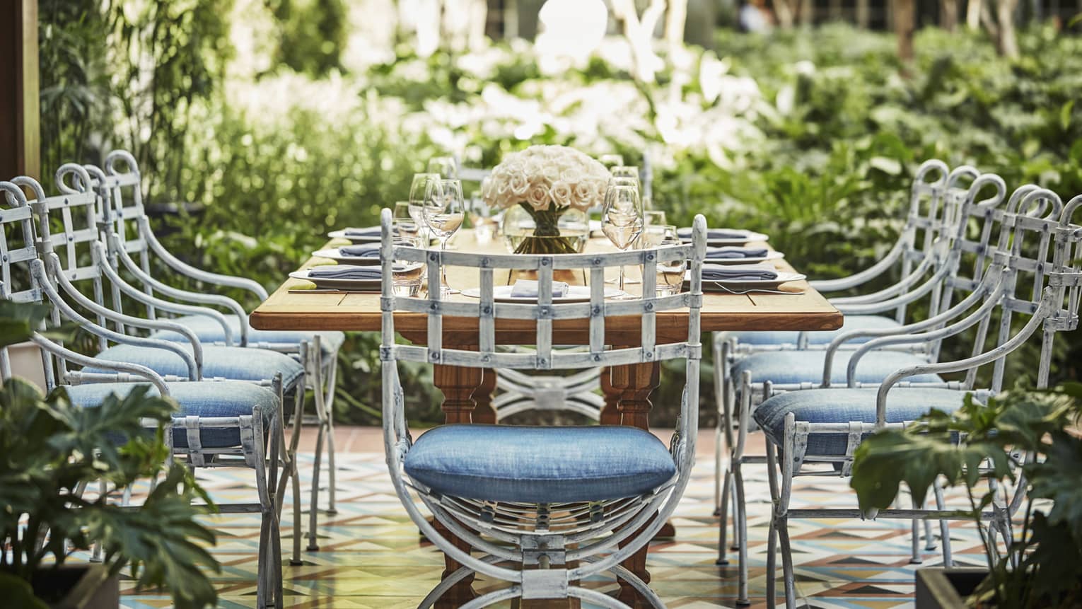 Patio dining table and chairs with blue cushions in garden courtyard