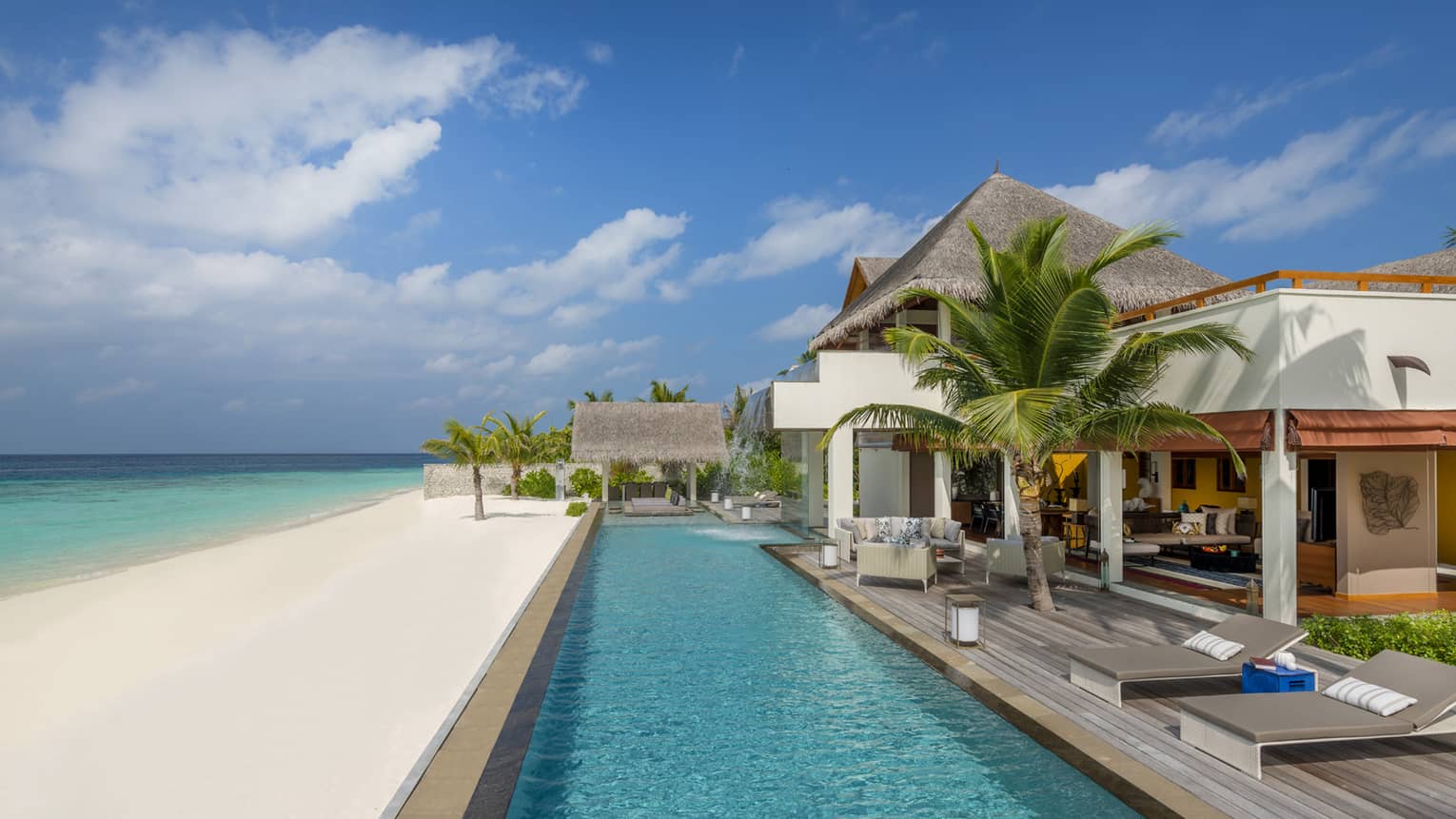 Three-Bedroom Landaa Estate villa deck by long swimming pool, white sand beach and ocean