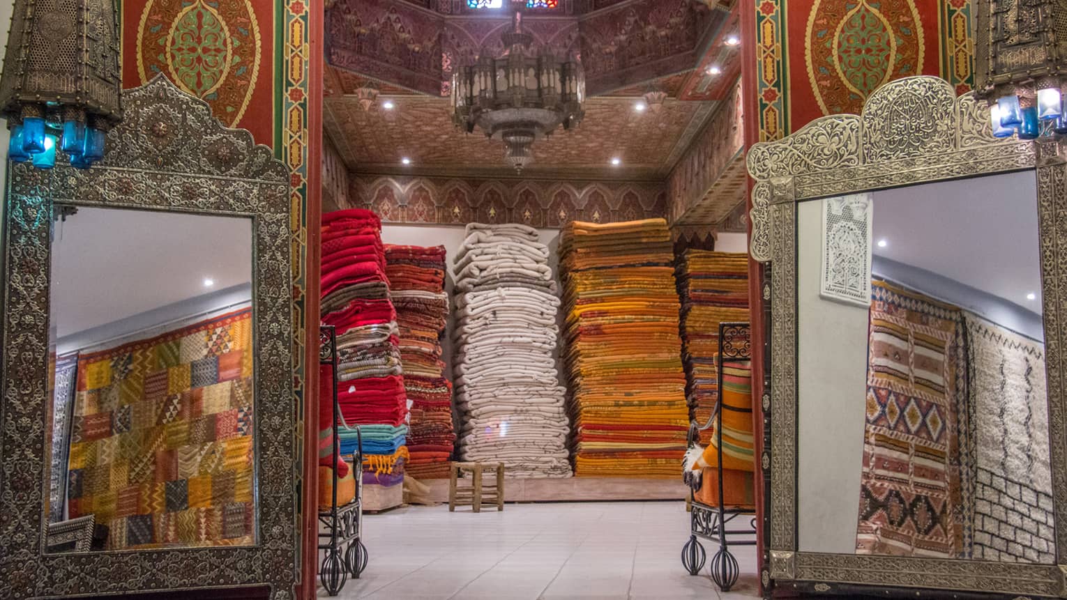 Large mirrors and stacks of colourful carpets in Marrakech