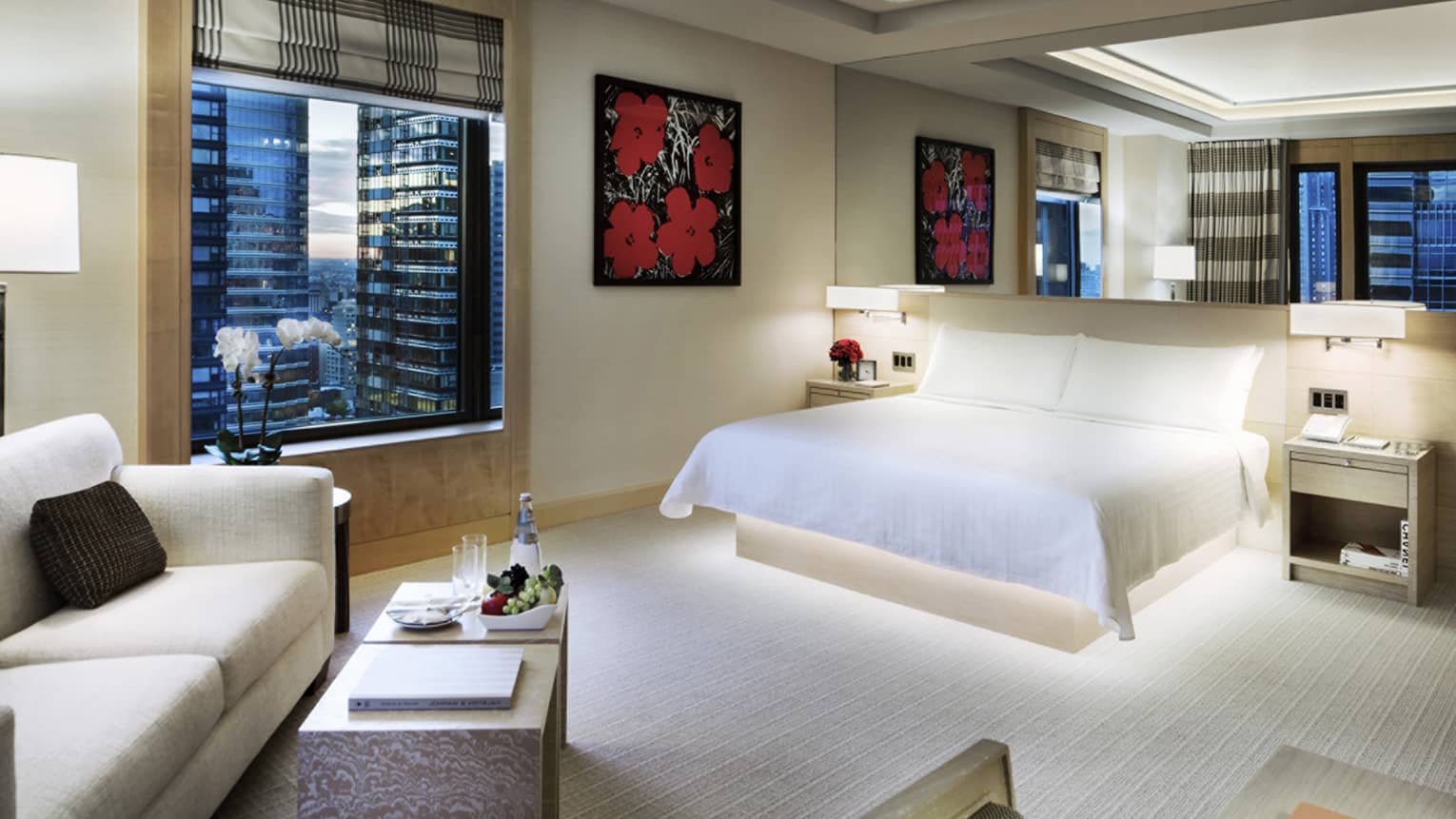 Manhattan Junior Suite King bed under mirror, print of red flowers, seating area