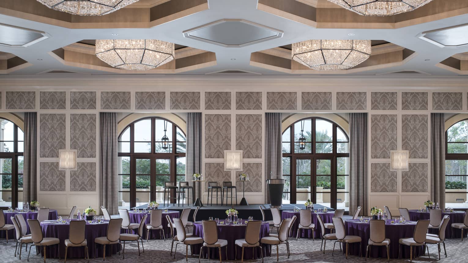 A ballroom at four seasons resort orlando at walt disney world is ready for guests with circular tables covered in purple table cloths
