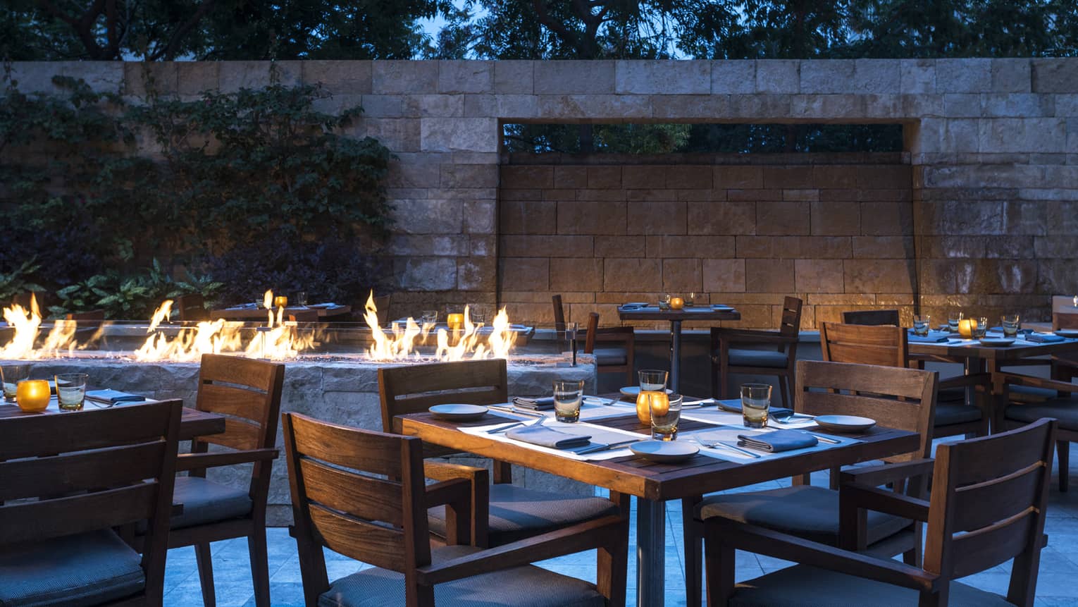 Flames leap from stone outdoor fireplace on Quattro restaurant patio