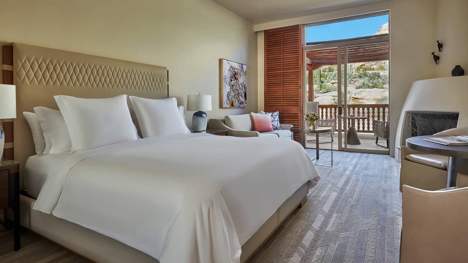 King-bedded room with wooden floors and a walk-out patio