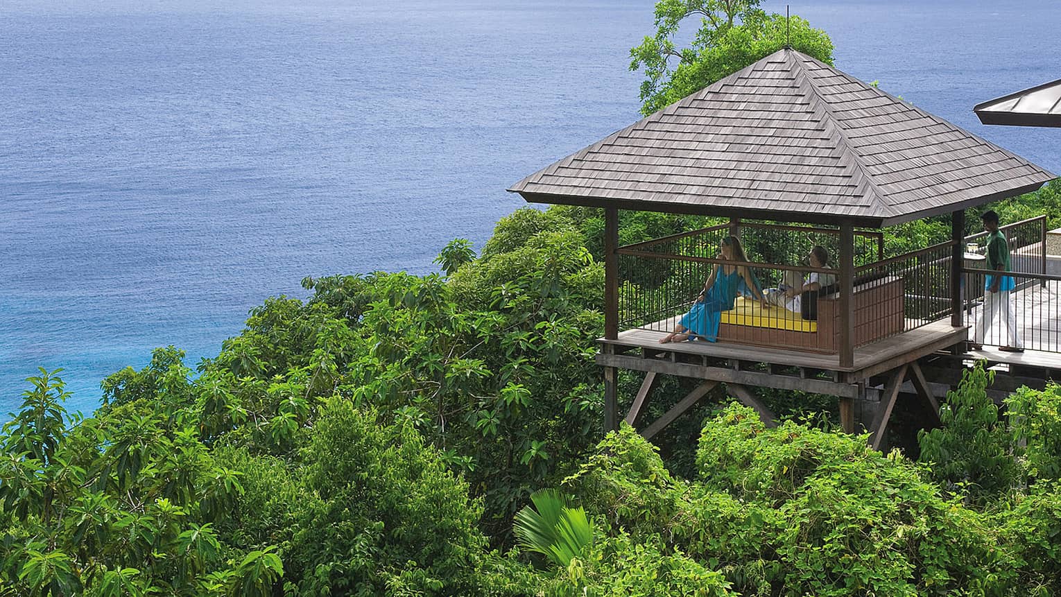 Five-Bedroom Residence Villa couple relax on bed in open-air pavilion on wood deck over tropical mountain