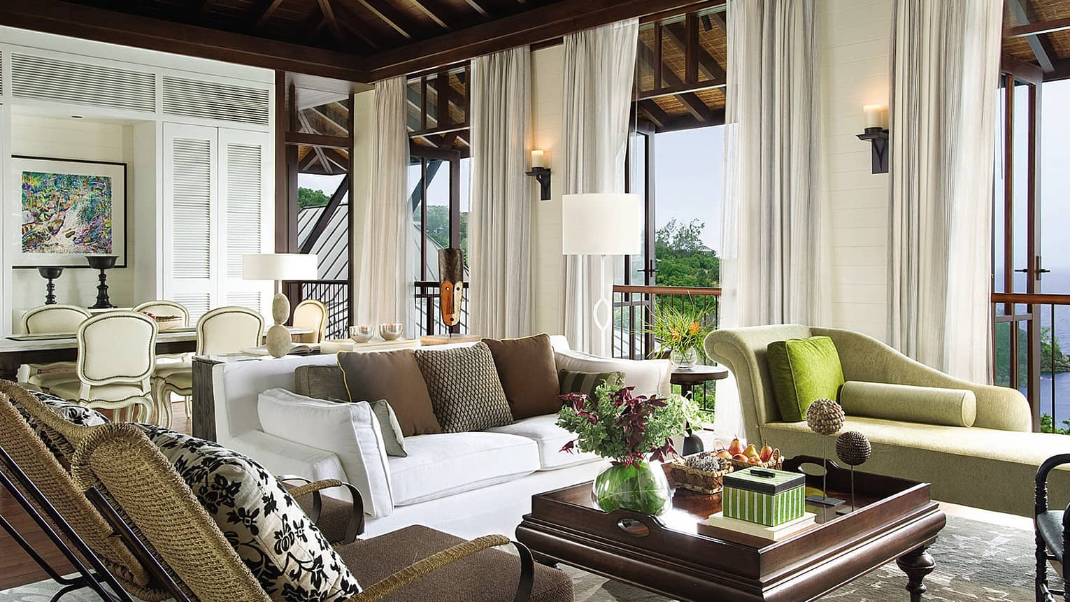 Two-Bedroom Ocean-View Suite living room with sofa, chaise lounge, two wicker chairs, open windows