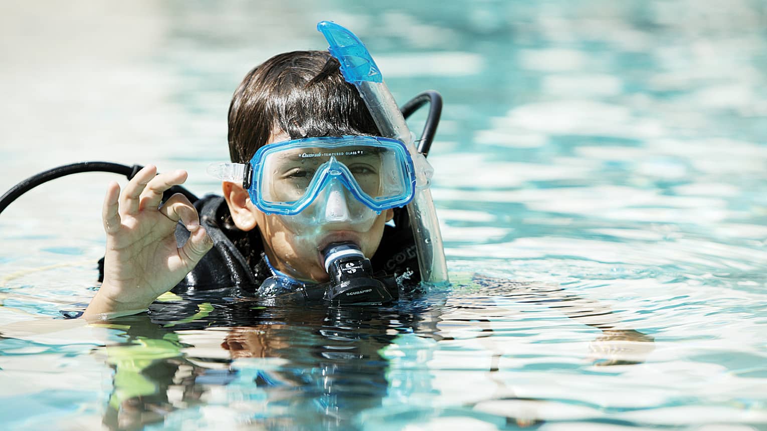 Young boy in scuba mask, snorkel with head above water 