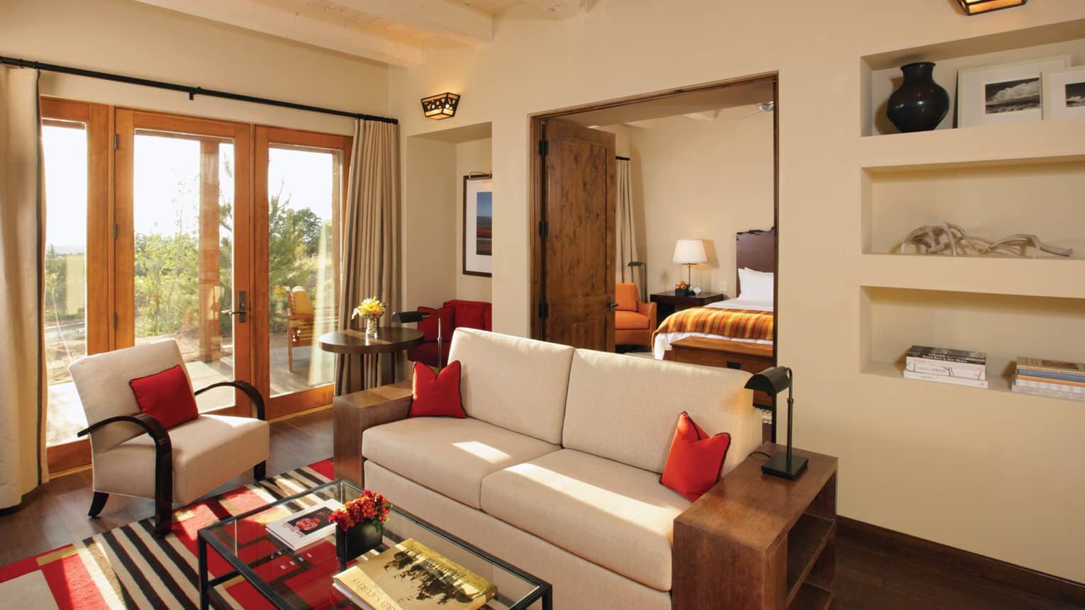 Summit Suite seating area with white loveseat, chair, open wood doors to bedroom