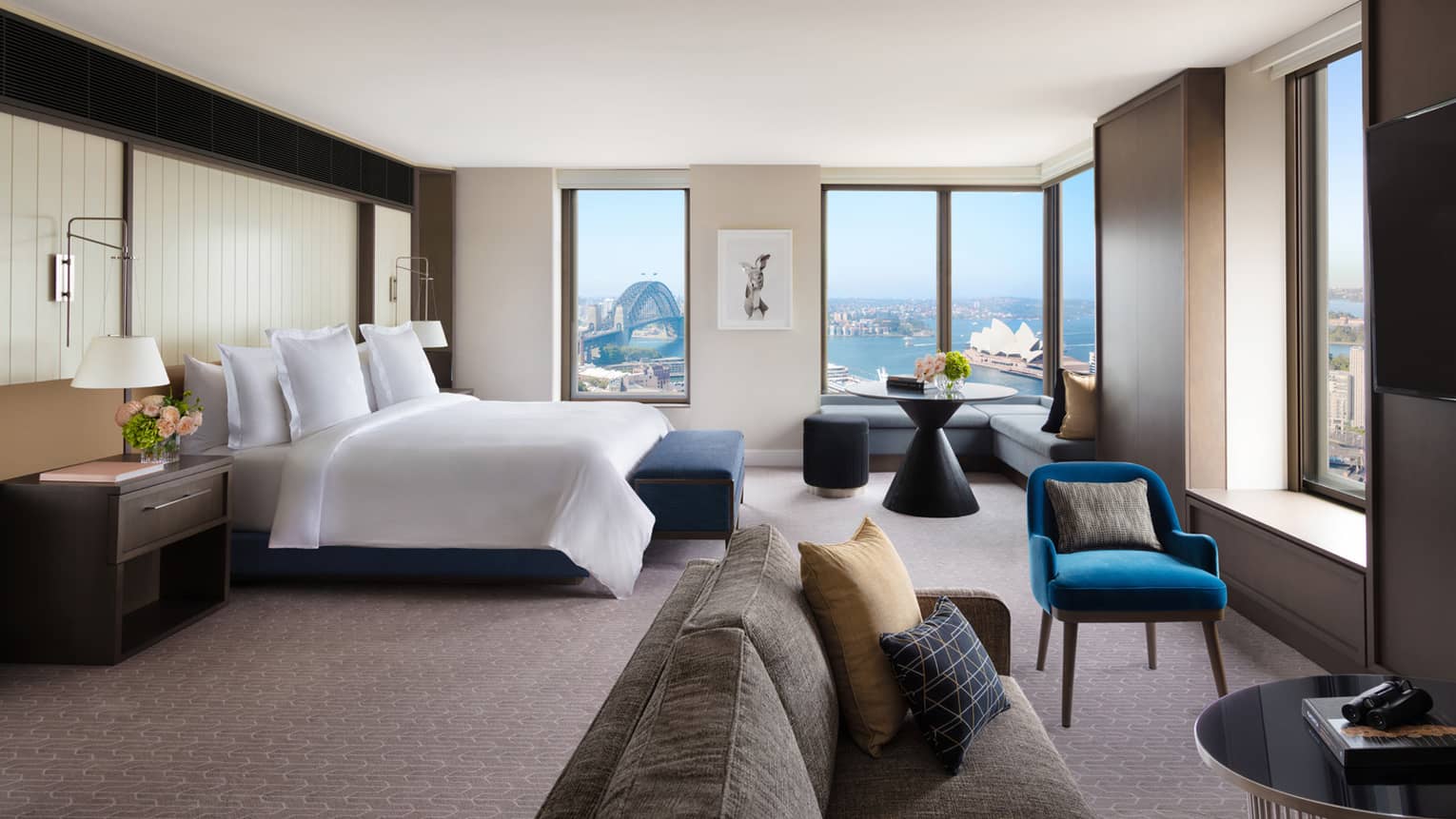 A cozy bedroom with subtle bursts of colourful decor, overlooking the iconic Sydney Harbour